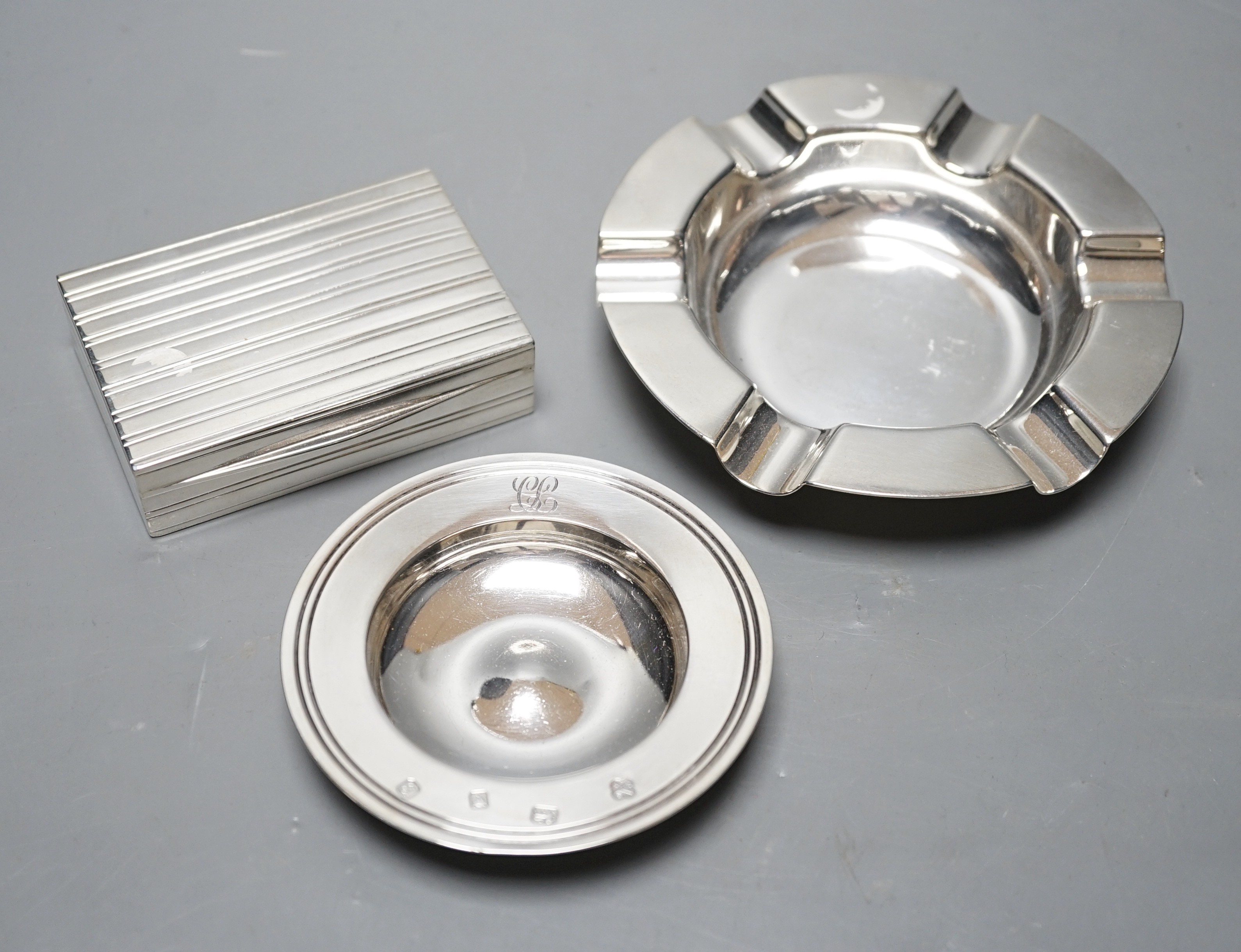 A George V silver ashtray, Mappin & Webb, Sheffield, 1928, 13cm, a modern Asprey & Co small dish and a continental white metal box and cover, gross 12.2oz.